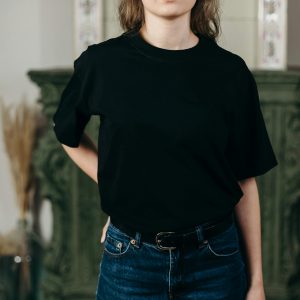 Home Faceless model in black t-shirt and jeans showcasing minimalist fashion style indoors.